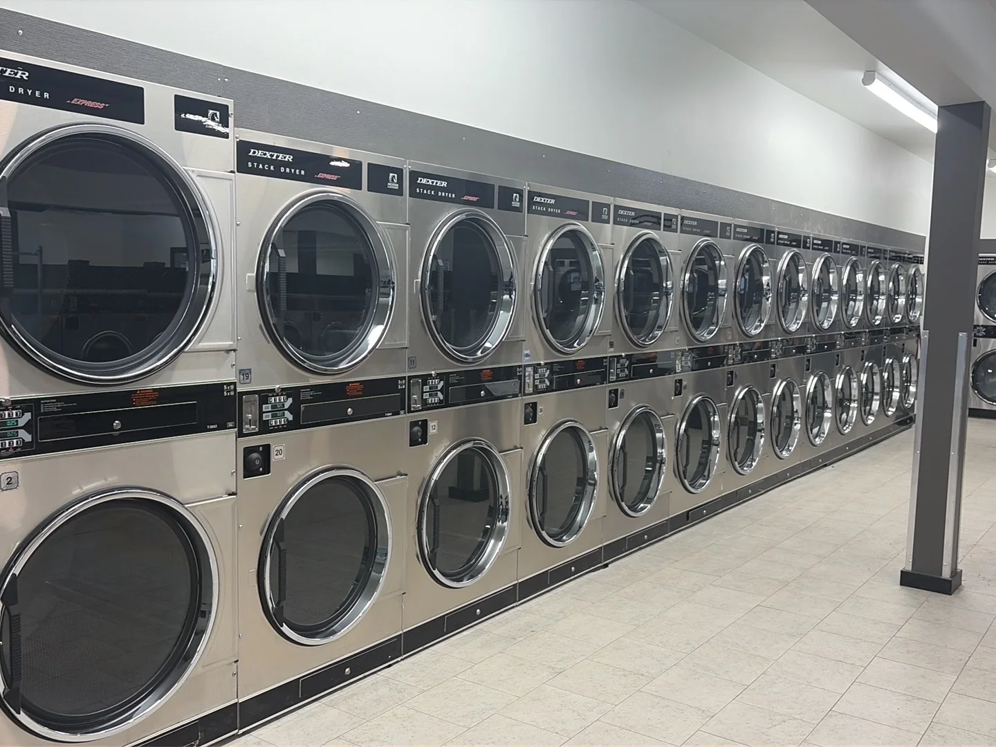 Row of new Dexter stack dryers inside the Colfax laundromat